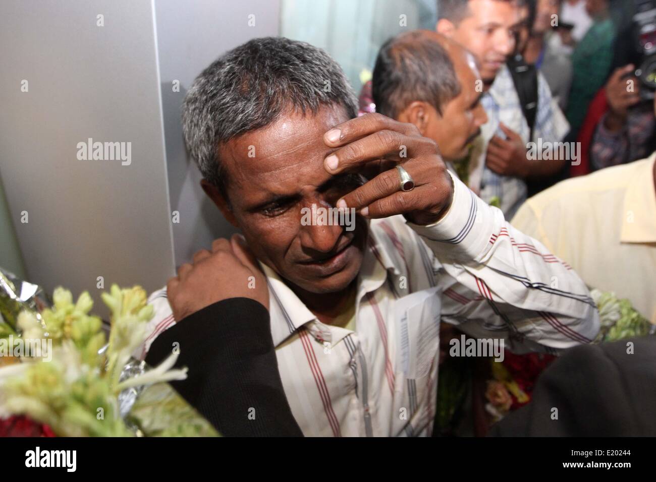 Dhaka, Bangladesh. 12th June, 2014. released Bangladeshi sailors Golam Mostafa cries as he arrives at Hazrat Shahjalal International Airports in Dhaka, Bangladesh, Thursday, June 12, 2014. Seven Bangladeshi crew members returned home Thursday after they were held captive for nearly three and a half years by Somali pirates. Stock Photo