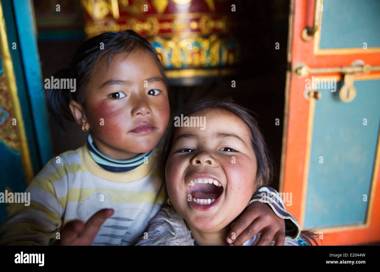 Lukla Nepal Young children pose in front of shrine and prayer wheel in Lukla Solukhumbu 56 Stock Photo