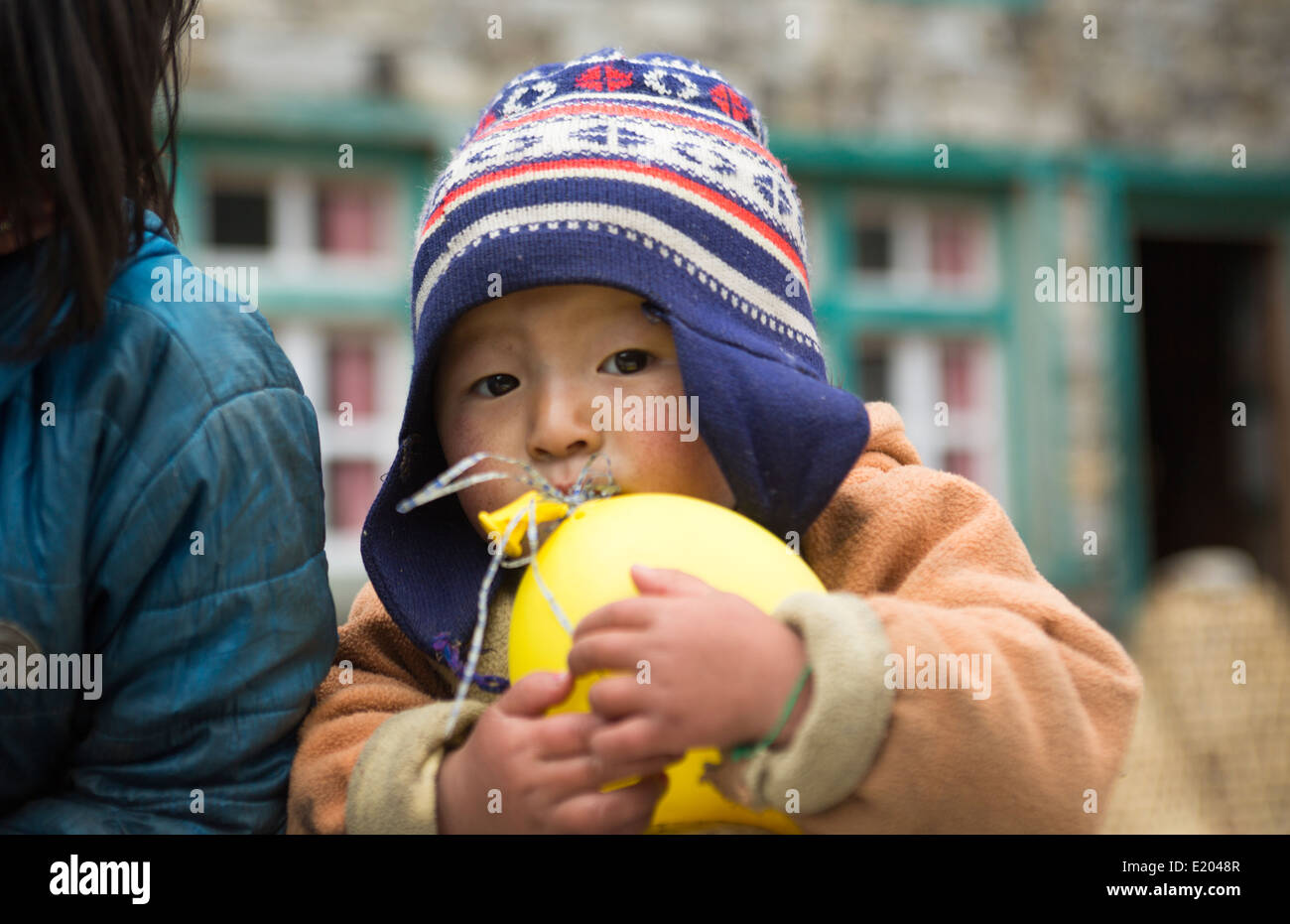 Nepal Himalayas Small child plays with balloon in the village of Monjo Solukhumbu remote Mt Everest 63 Stock Photo