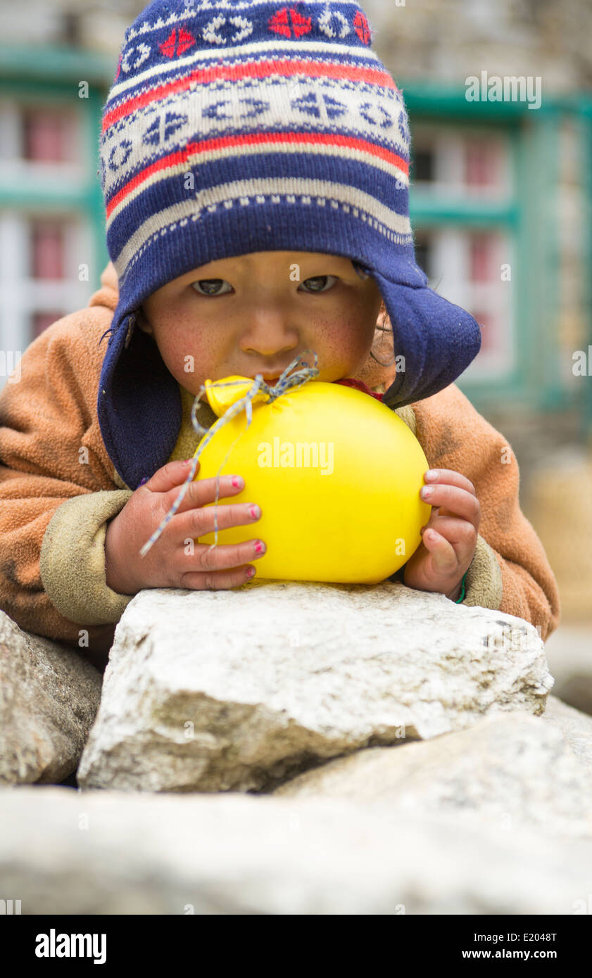 Nepal Himalayas Small child plays with balloon in the village of Monjo Solukhumbu remote Mt Everest 63 Stock Photo