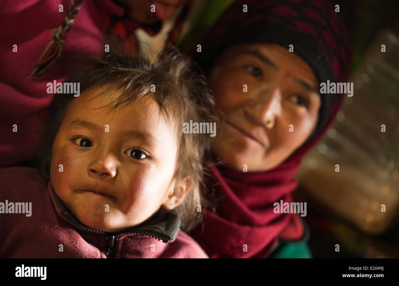 Nepal Himalayas Sherpa mother holds child in home in Namche Bazarre remote Mt Everest 75 Stock Photo