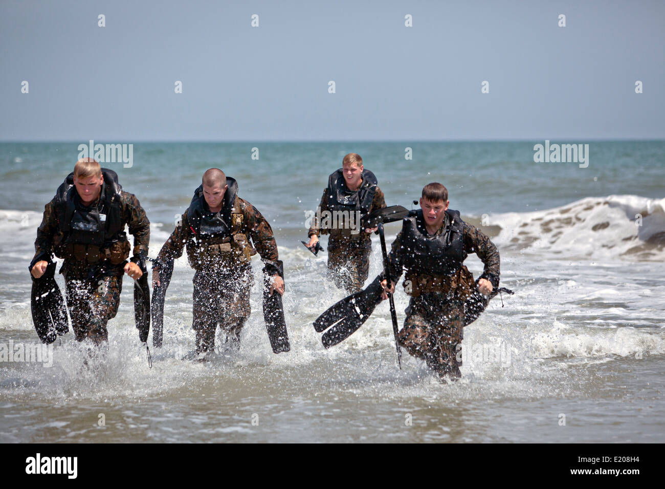 US. Marine reconnaissance commandos come ashore after conducting a hard duck insertion at Onslow Bech June 4, 2014 in Camp Lejeune, N.C. A hard duck insertion involves dropping a fully inflated rubber boat with Marines into the water from a helicopter. Stock Photo