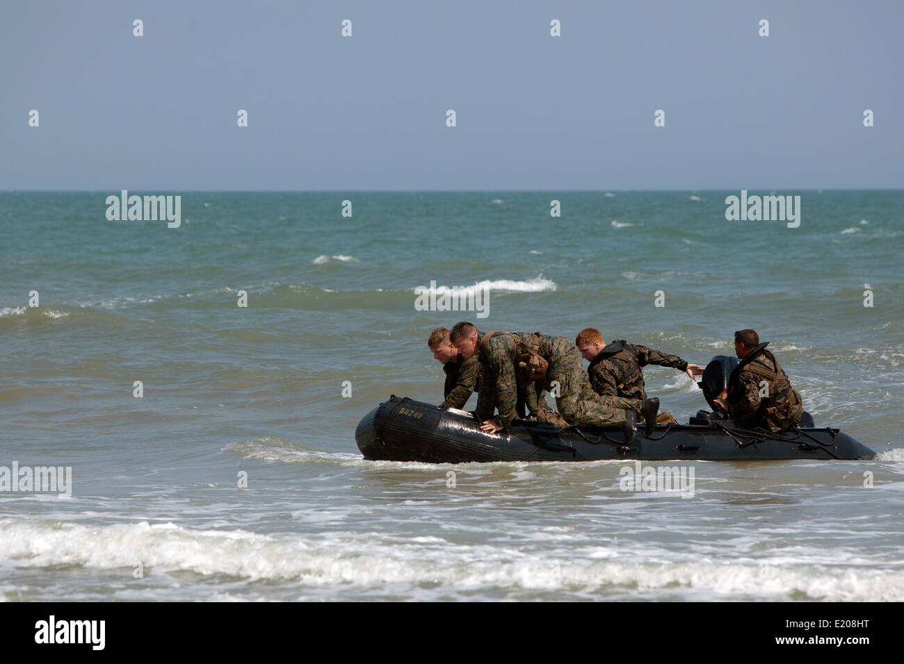 US Marines reconnaissance commandos maneuver an F470 combat rubber raiding craft after conducting a hard duck insertion at Onslow Beach June 4, 2014 in Camp Lejeune, N.C. A hard duck insertion involves dropping a fully inflated rubber boat with Marines into the water from a helicopter. Stock Photo