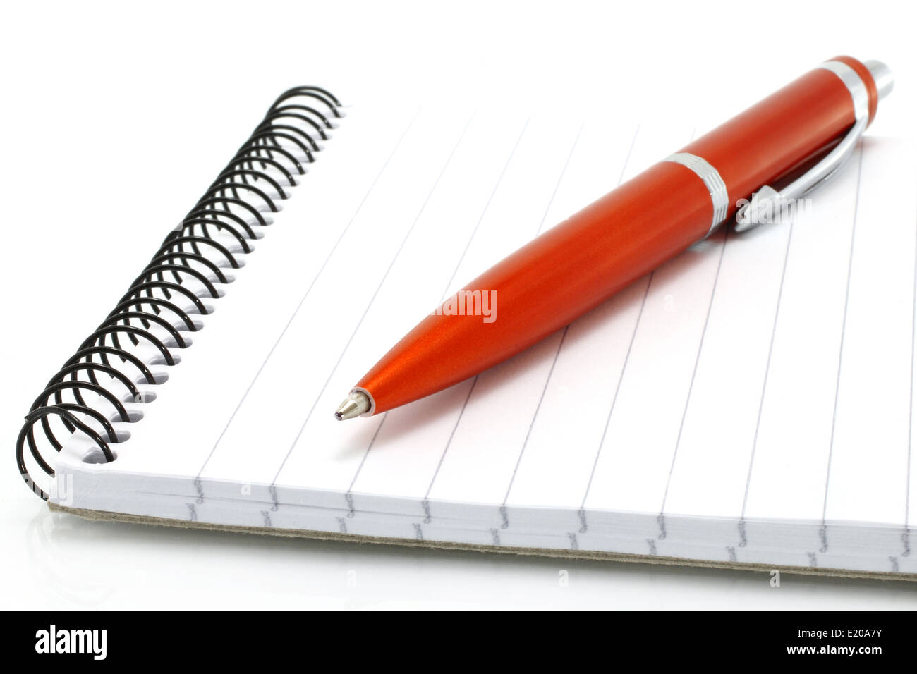 Notepad with orange ball pen on a white background Stock Photo - Alamy