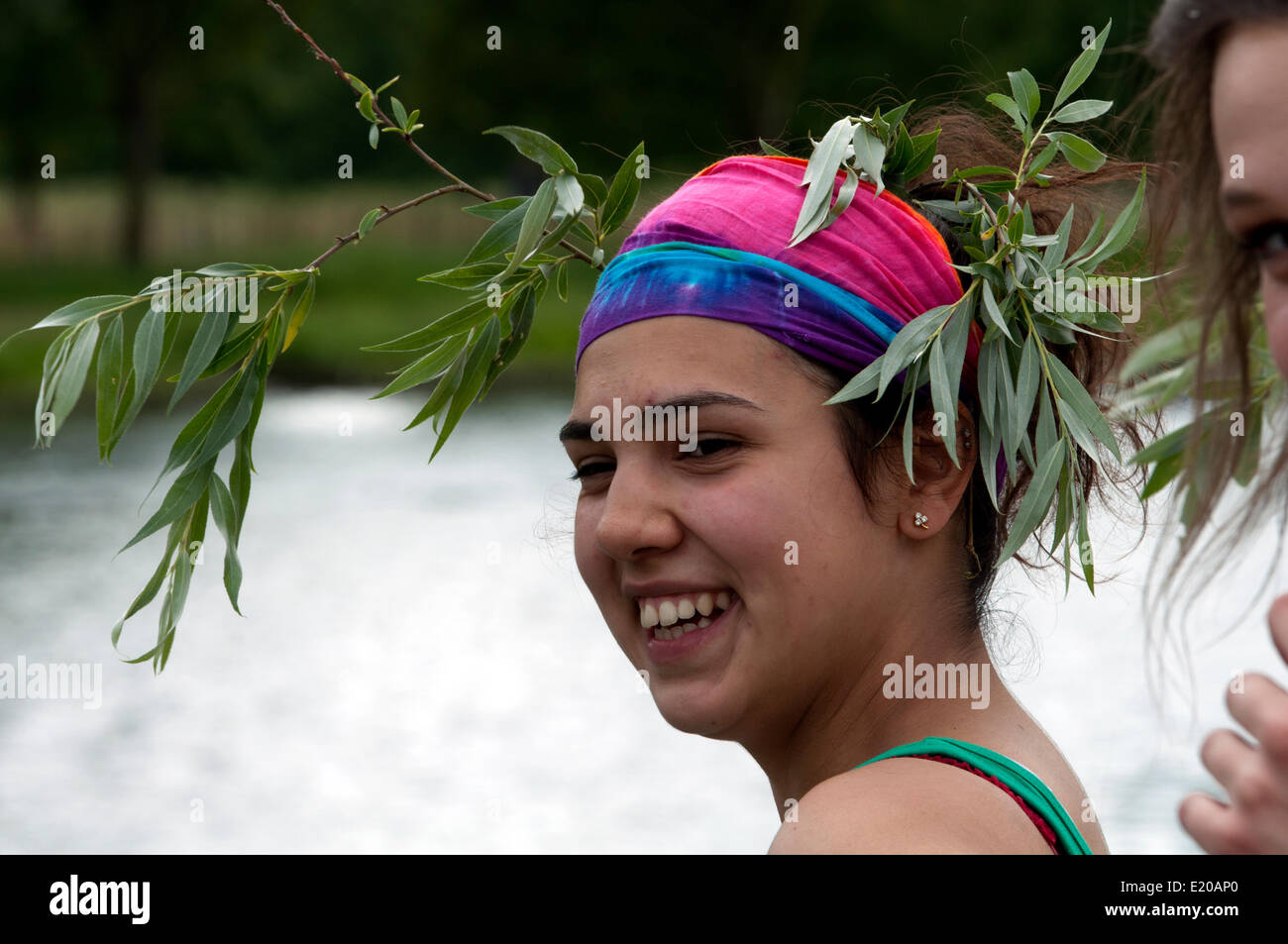 Cambridge, Cambridgeshire, UK. 11th June, 2014.  A member of a Queens College ladies eight wears traditional willow tree decorations after their boat achieved a successful bump during the Cambridge May Bumps. This annual rowing event between colleges of the university is being held over four days and finishes on Saturday 14th June. Credit:  Colin Underhill/Alamy Live News Stock Photo