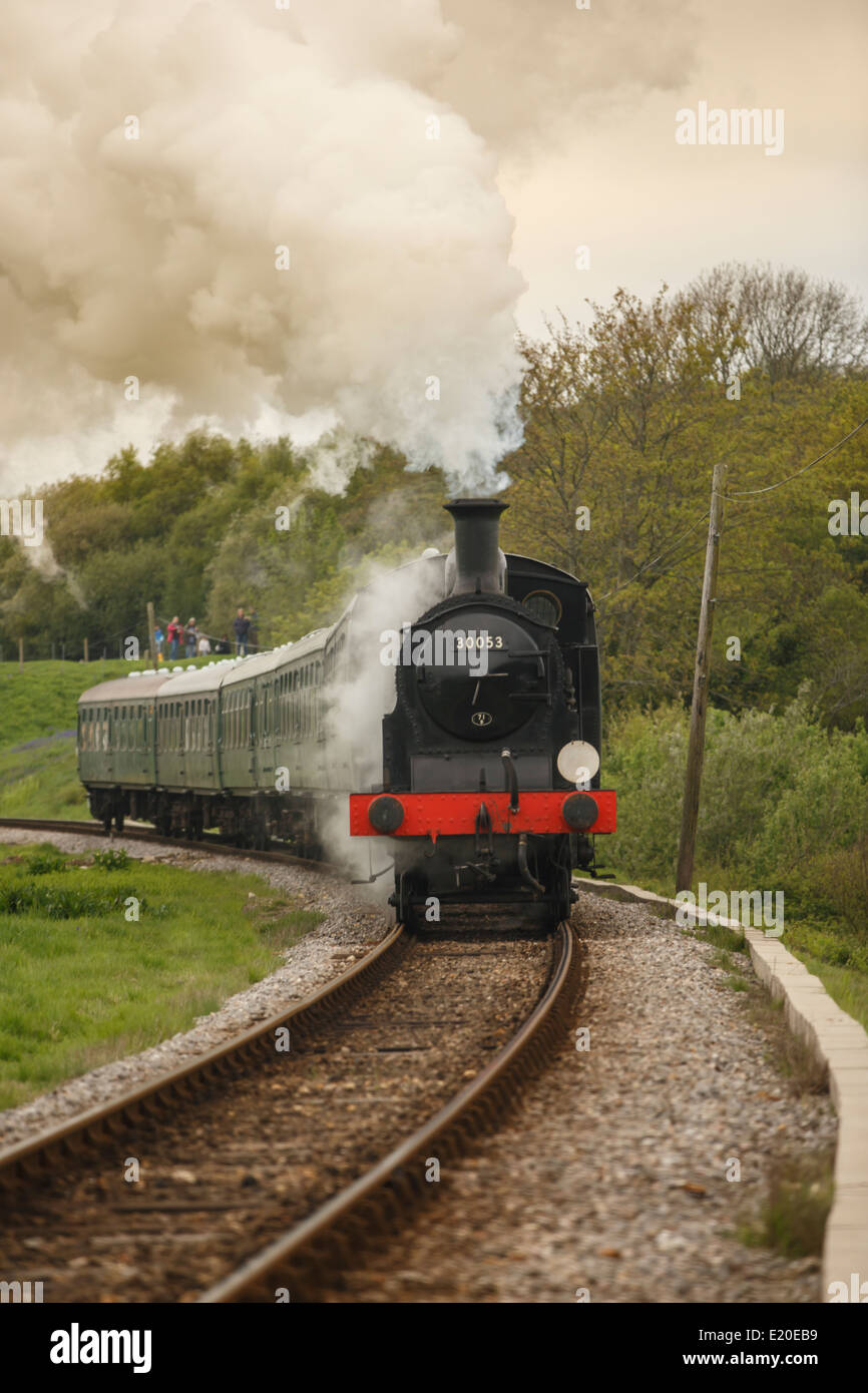 Steam train traveling towards Corfe Castle, Purbeck Hills, Dorset Stock Photo