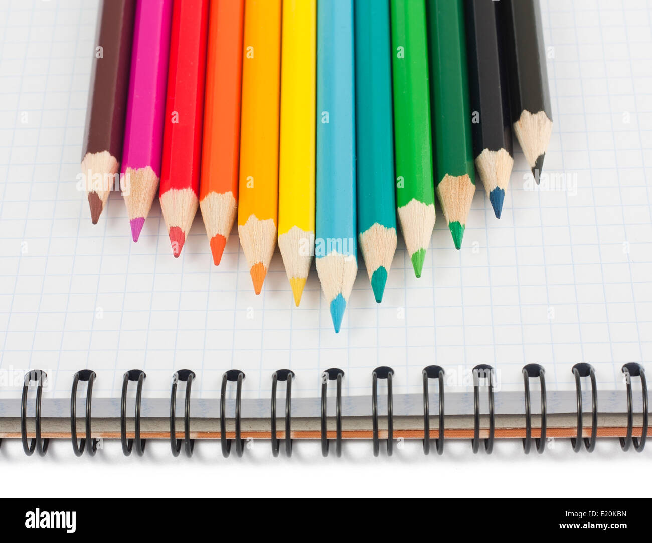 Multicolored pencils on spiral notebook Stock Photo