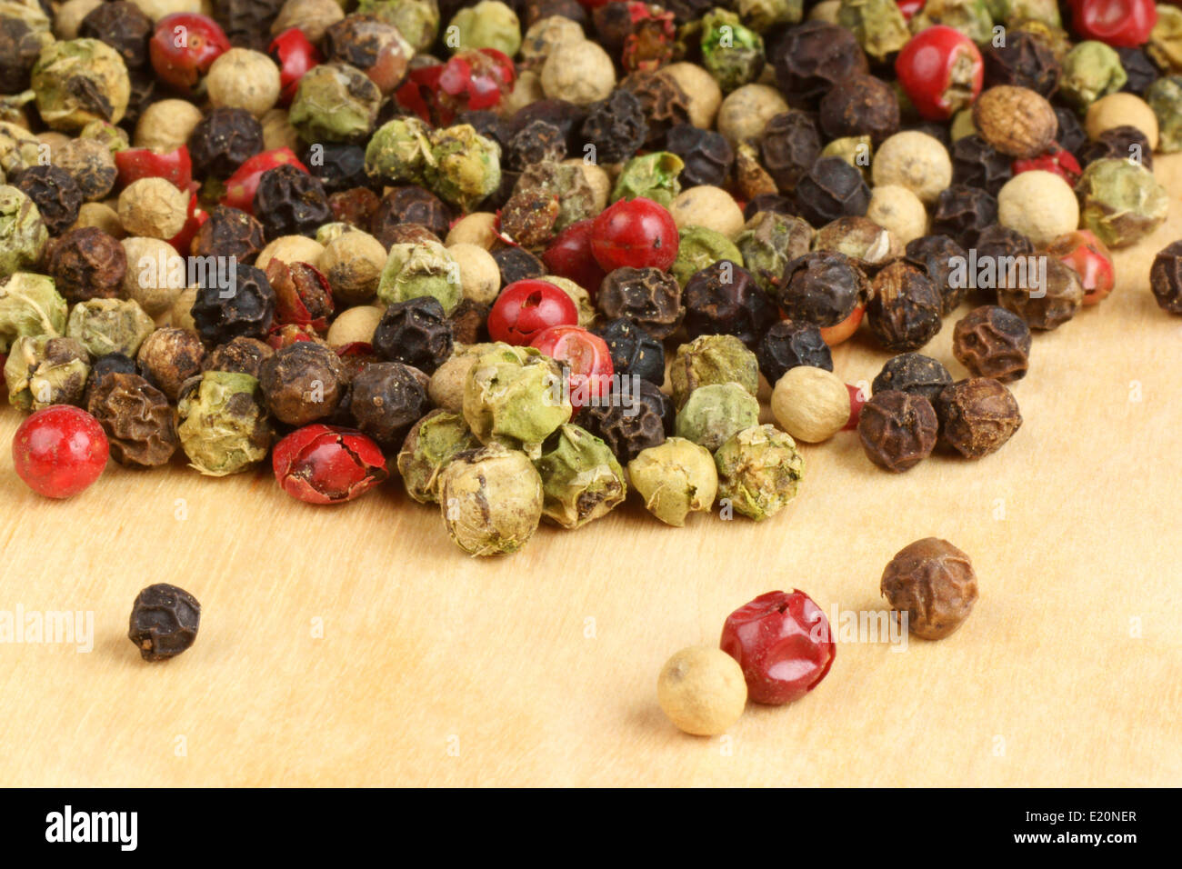Four seasons dried peppercorns over a wooden background with copy space