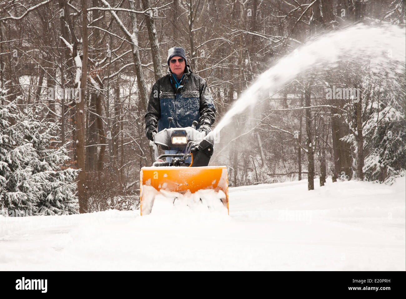 Man pushing snowblower on driveway Stock Photo Alamy