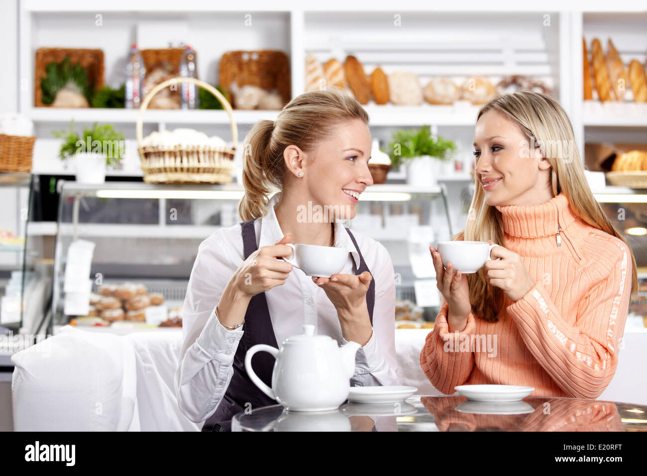 Two nice girls drink tea in cafe Stock Photo