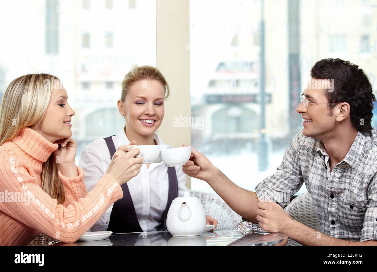 Young people with tea cups in cafe Stock Photo