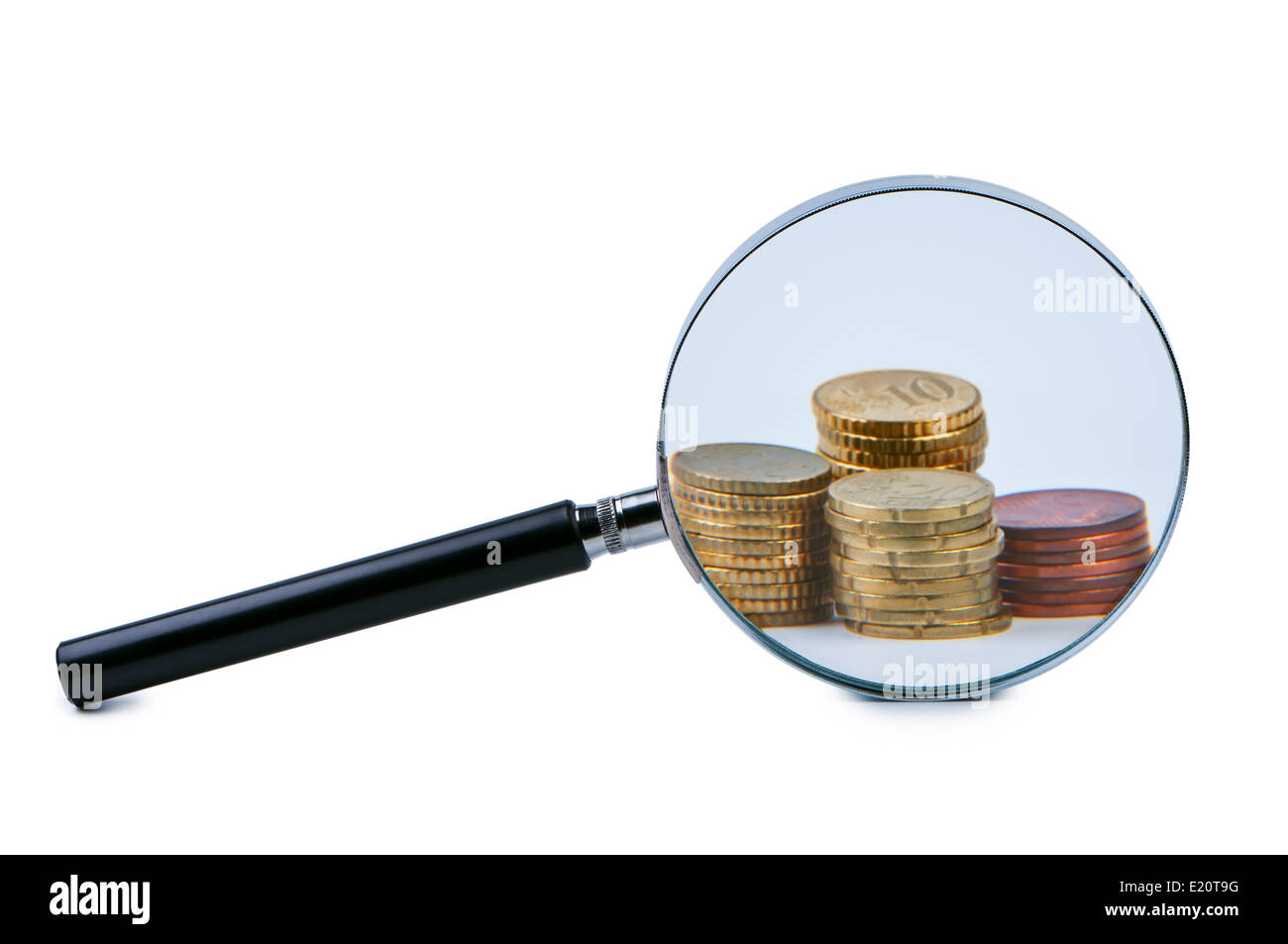 Magnifying Glass On A Few Stacks Of Money Coins Stock Photo