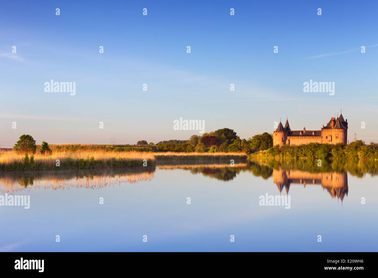 A medieval castle reflected in a lake at sunrise Stock Photo - Alamy