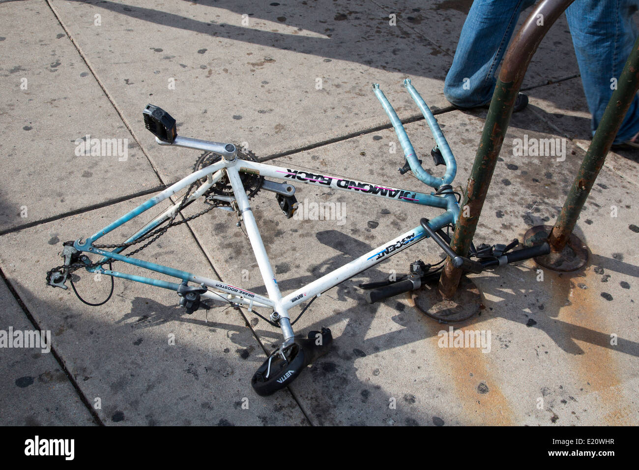 Denver, Colorado - A bicycle frame locked to a bike stand with the wheels removed. Stock Photo