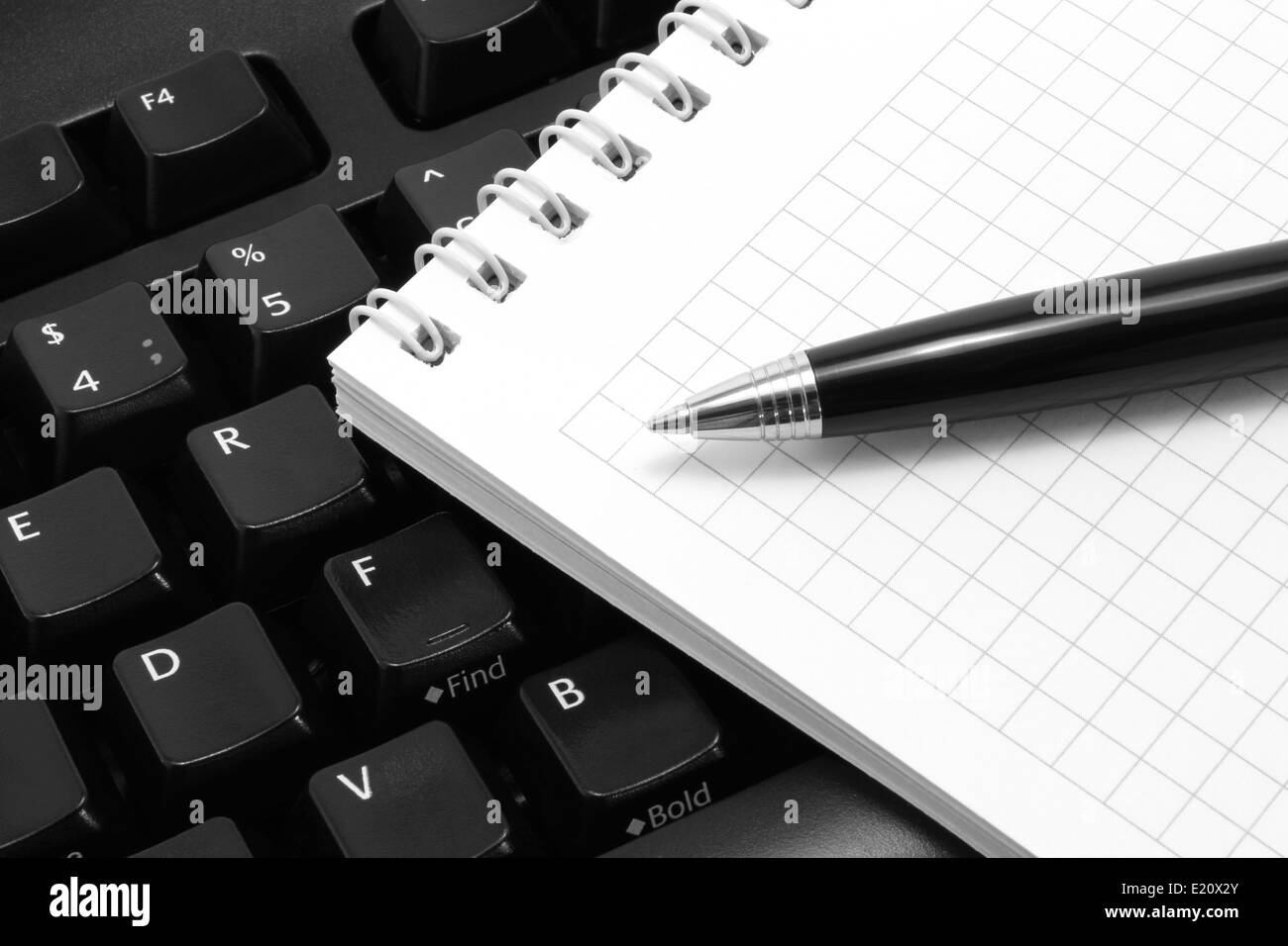 Notepad with pen on a black computer keyboard background Stock Photo