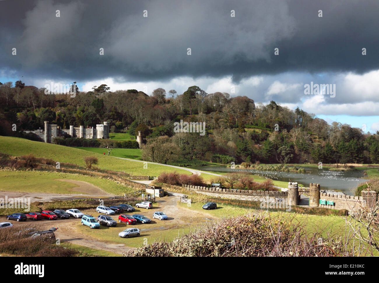 A turretted castle with a car park under dark skies. Stock Photo