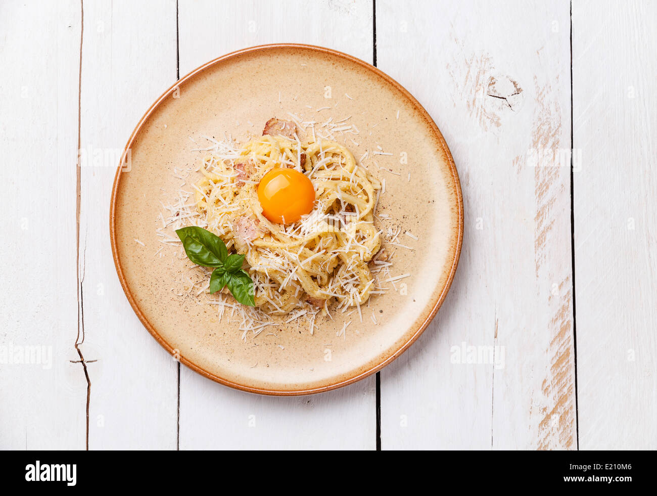Pasta Carbonara with parmesan and yolk on white wooden background Stock Photo