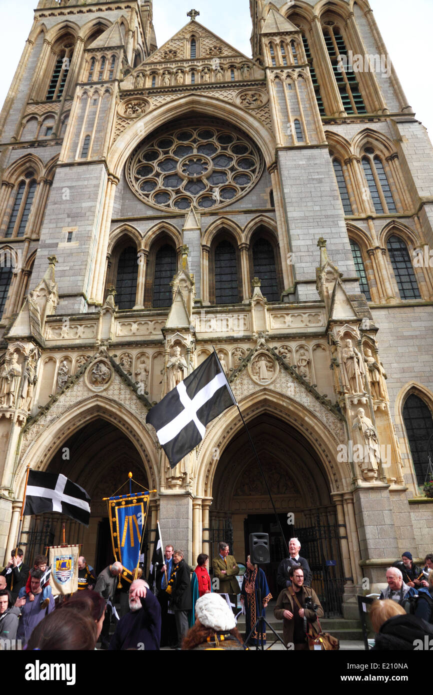 A Gothic-style cathedral with a group of people waving a black and white flag. Stock Photo