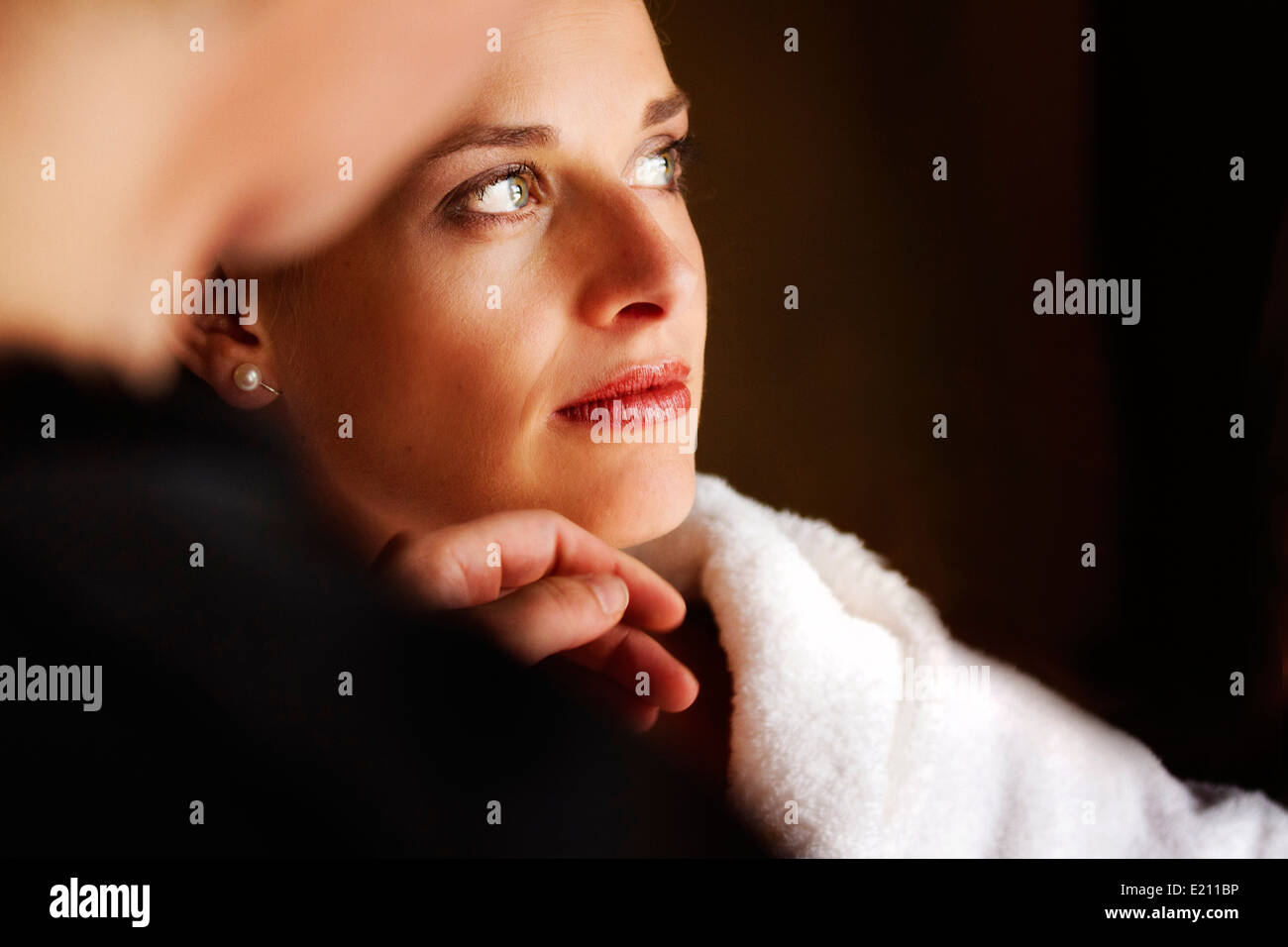 Make up artist adding make up to a strikingly beautiful bride Stock Photo