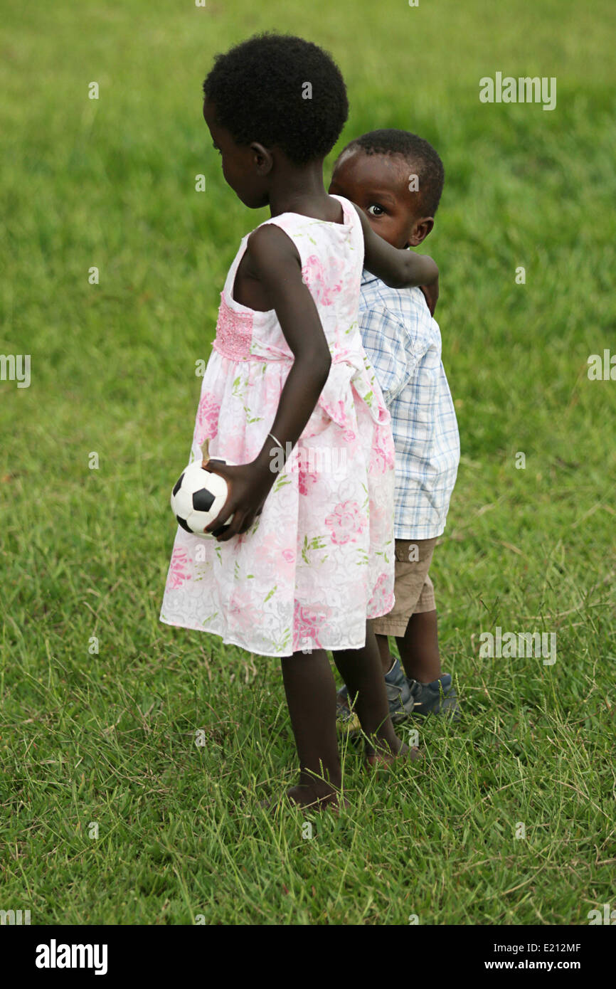 A young girl and even younger boy, both orphans,comfort one another Stock Photo