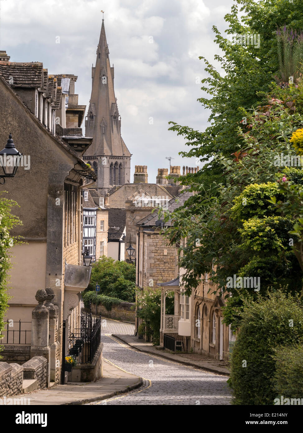 Old narrow cobbled street with stone houses and St Marys Church spire, Barn Hill, Stamford, Lincolnshire, England, UK Stock Photo