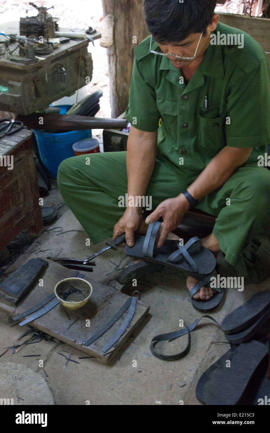 A man showing how the Viet Cong make shoes from discarded vehicle tyres at the Cu Chi Tunnels in Ho Chi Minh City, Vietnam. Stock Photo