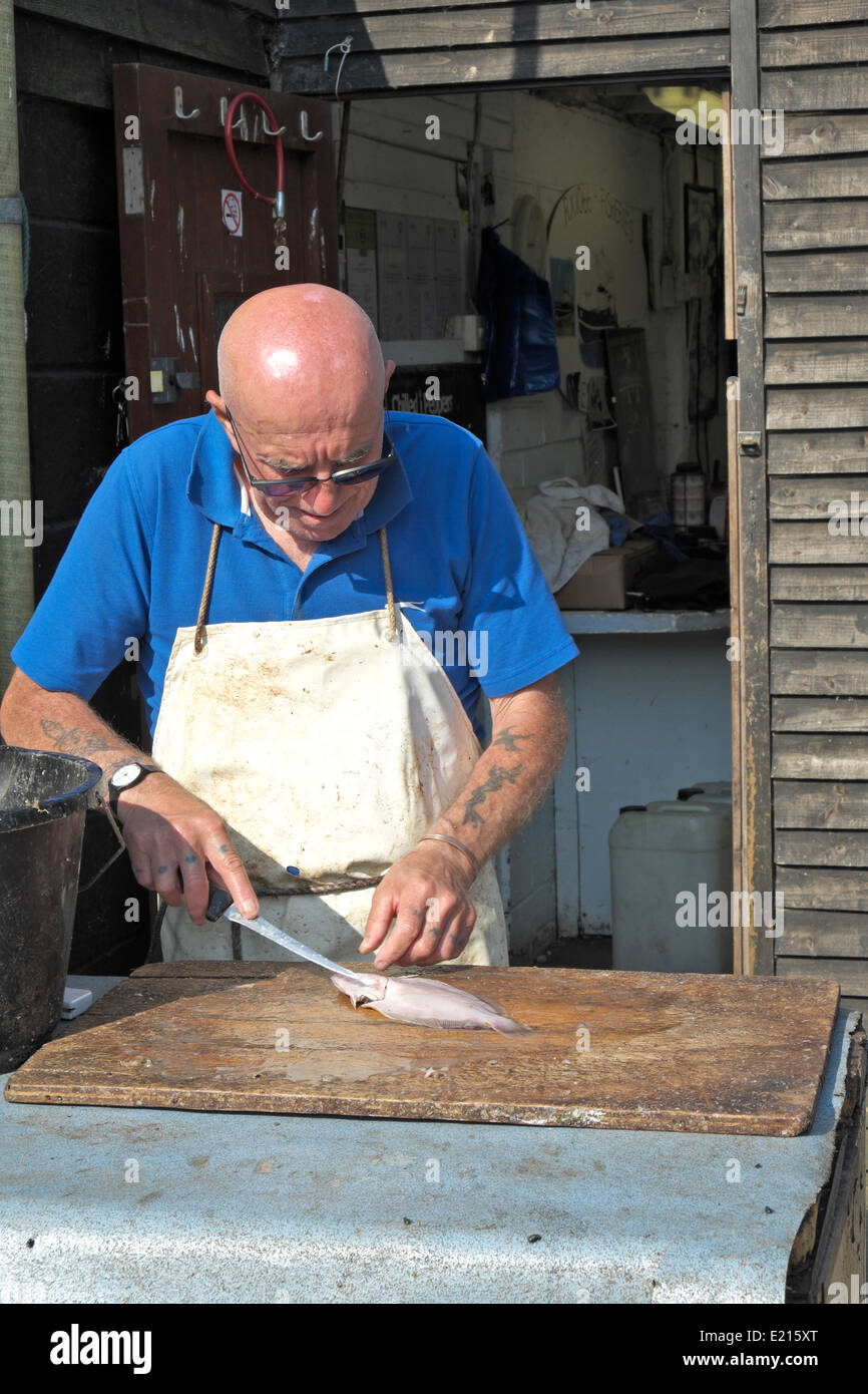 Fishmonger filleting local caught fish on the seafront Stade beach at