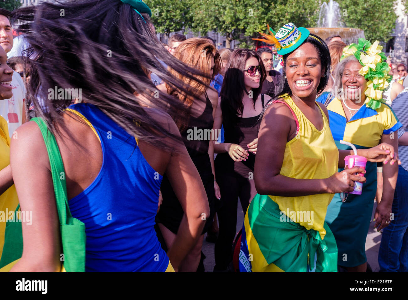 Women dressed in Brazilian colours dance at the Brazil Day festival, London UK Stock Photo