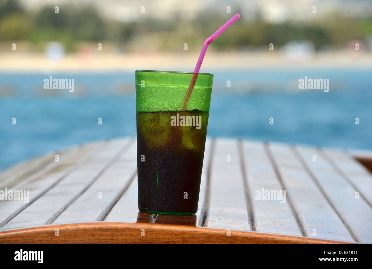 Vodka & coke in a green plastic glass on the Jolly Roger II. Stock Photo