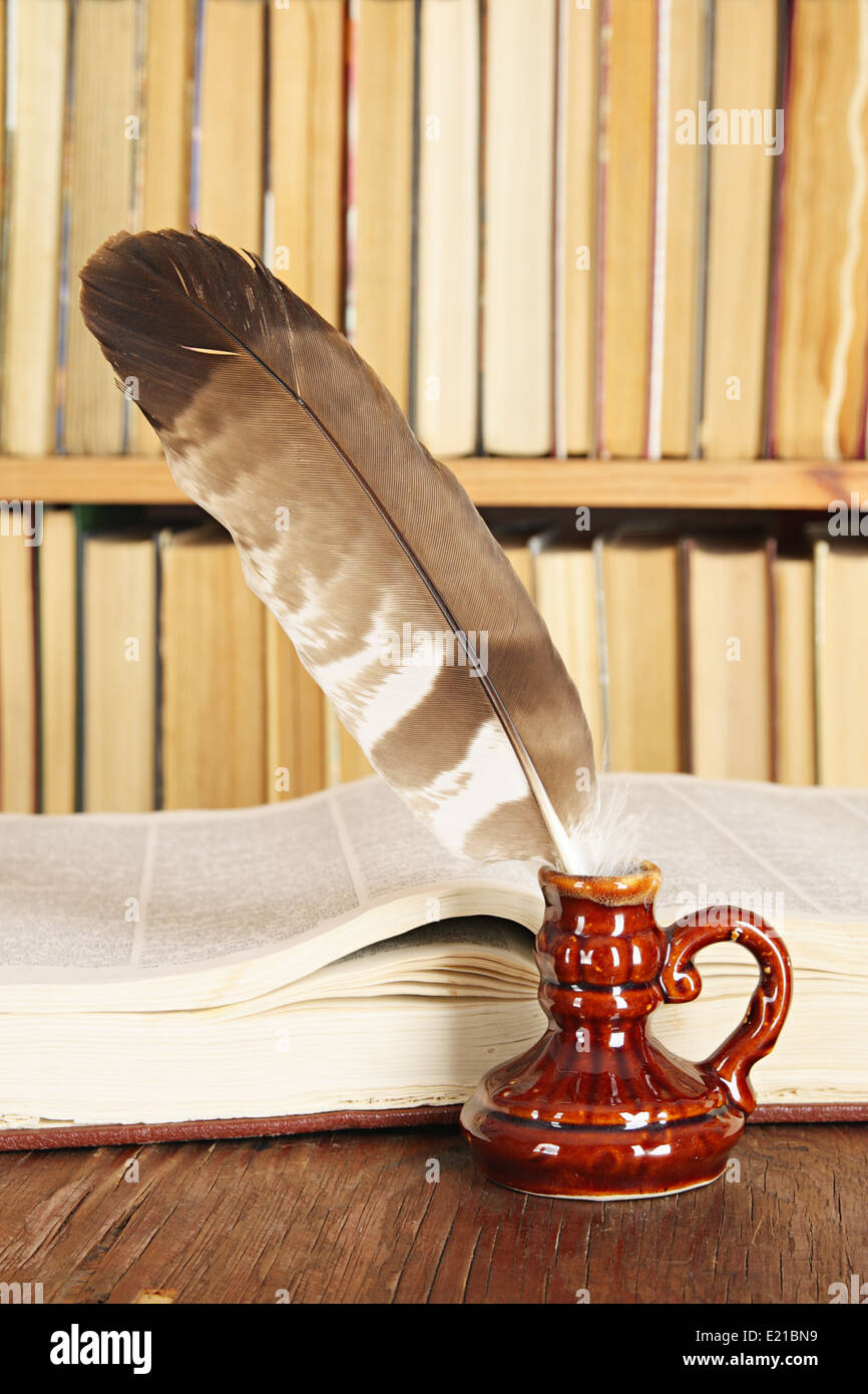 Vintage still-life. Quill in inkstand on a background of books Stock Photo