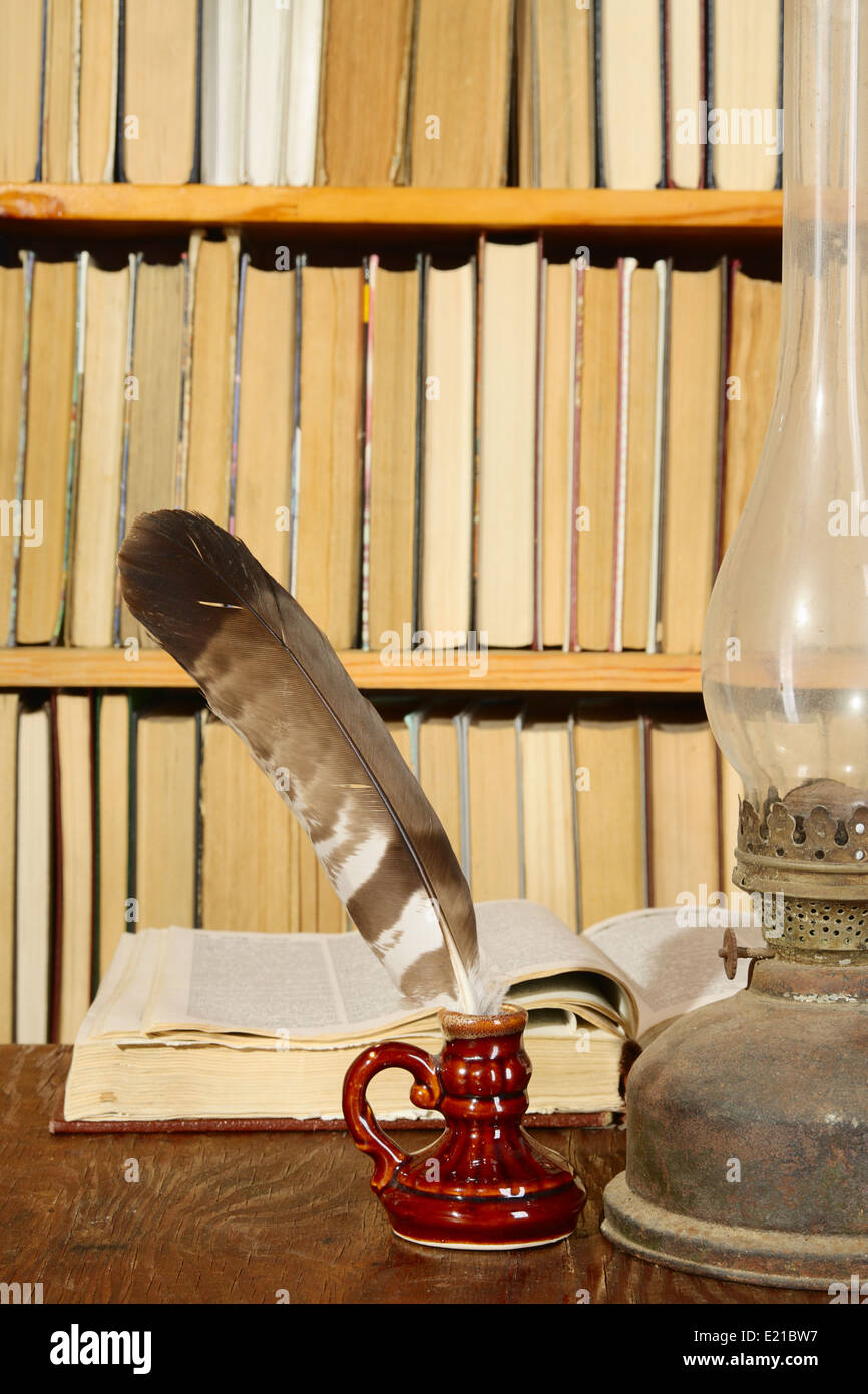 Vintage still-life with books, quill and parafin lamp Stock Photo