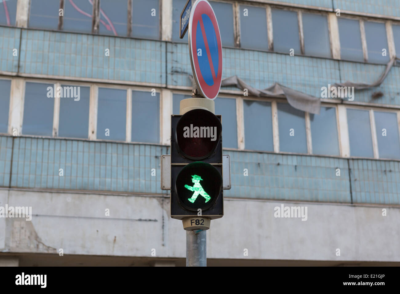 Traffic light with 'Ampelmännchen' in Magdeburg with an empty flat building. These traffic lights were made in the former GDR DDR Stock Photo