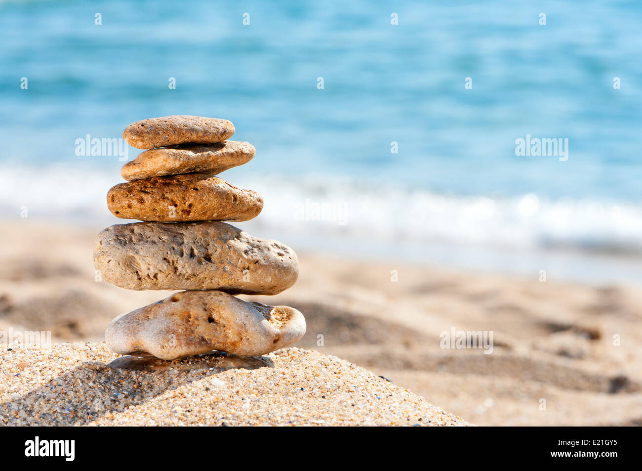 Stone tower in sand against sea. Stock Photo