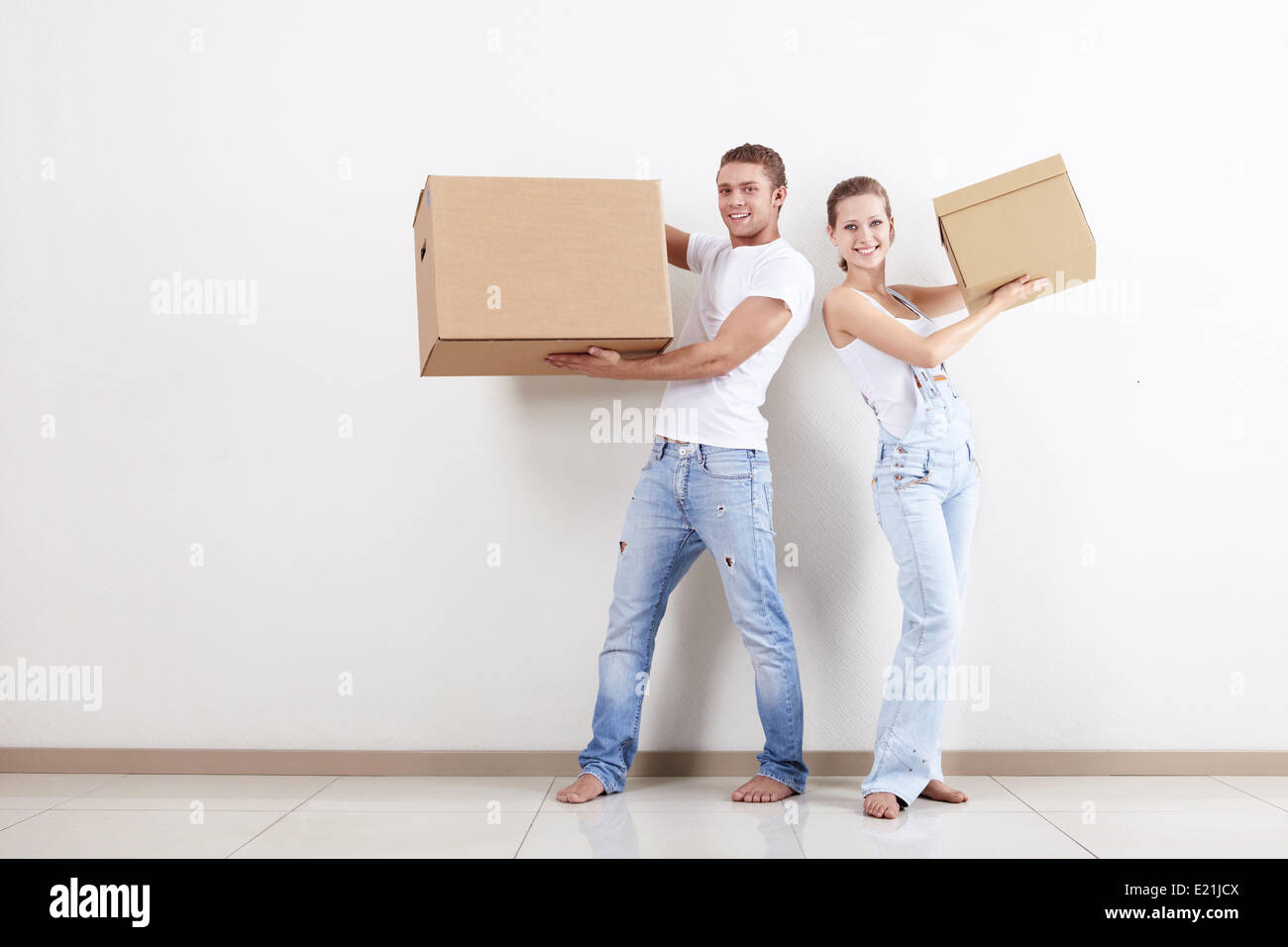 A smiling young couple with a cardboard box Stock Photo - Alamy