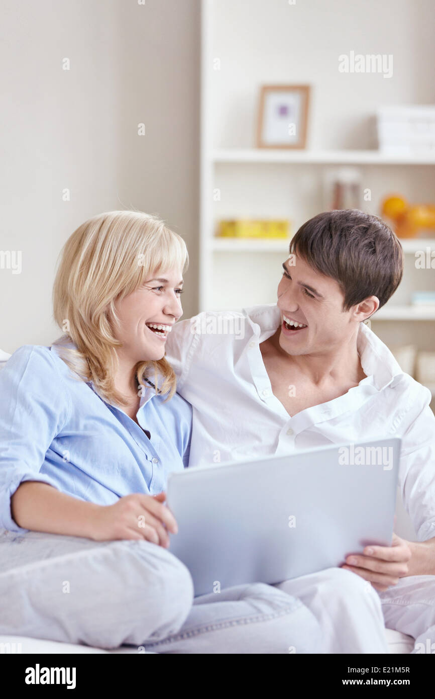 Happy young couple with laptop Stock Photo - Alamy