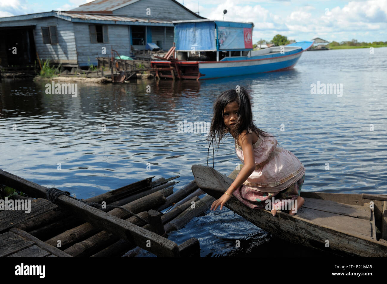 Girl on a boat reaching her floating house, Tonle Sap Lake, Cambodia Stock Photo