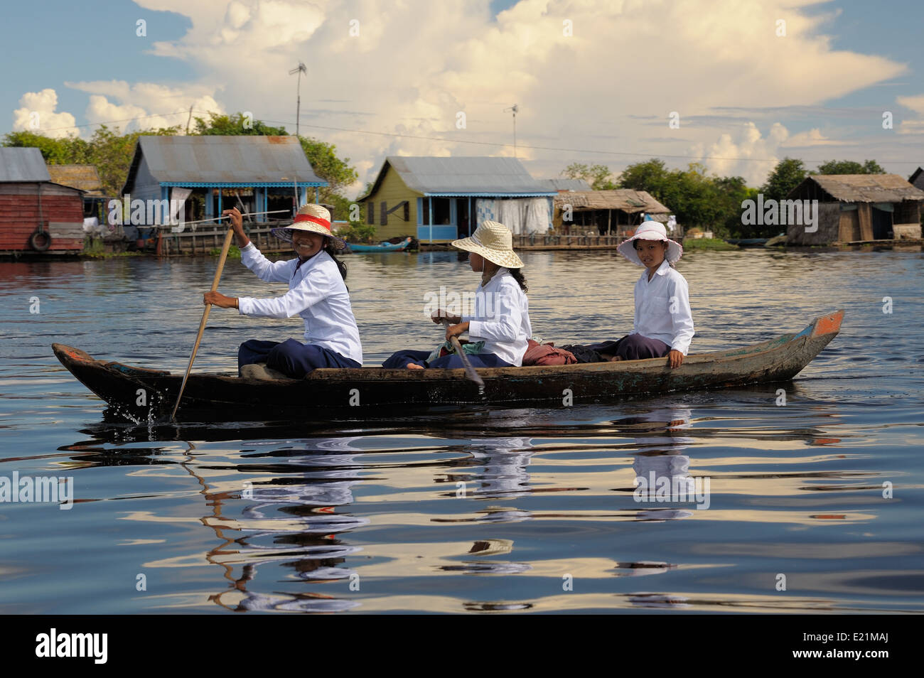 Girls commuting to school on a small raw boat on the Tonle Sap Lake in Cambodia Stock Photo