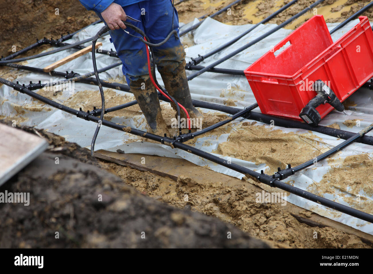 Craftsmen in a pit with geothermal pipes Stock Photo