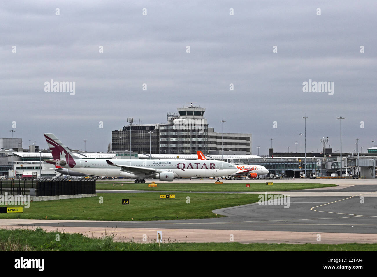 Manchester Airport, England, with Qatar Airways Airbus A330 in foreground Stock Photo