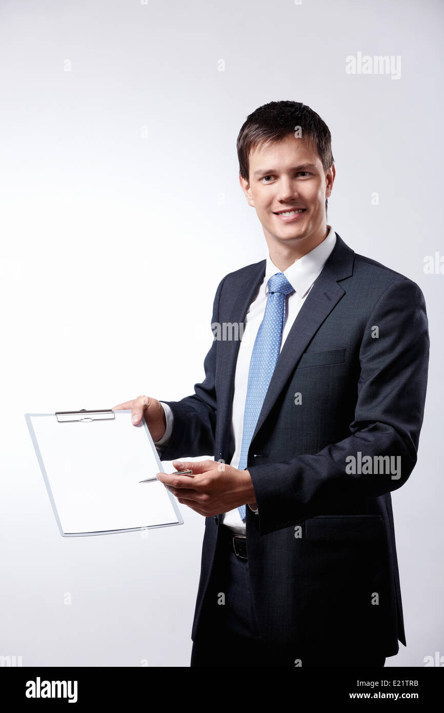 A young businessman with pen and clipboard Stock Photo - Alamy