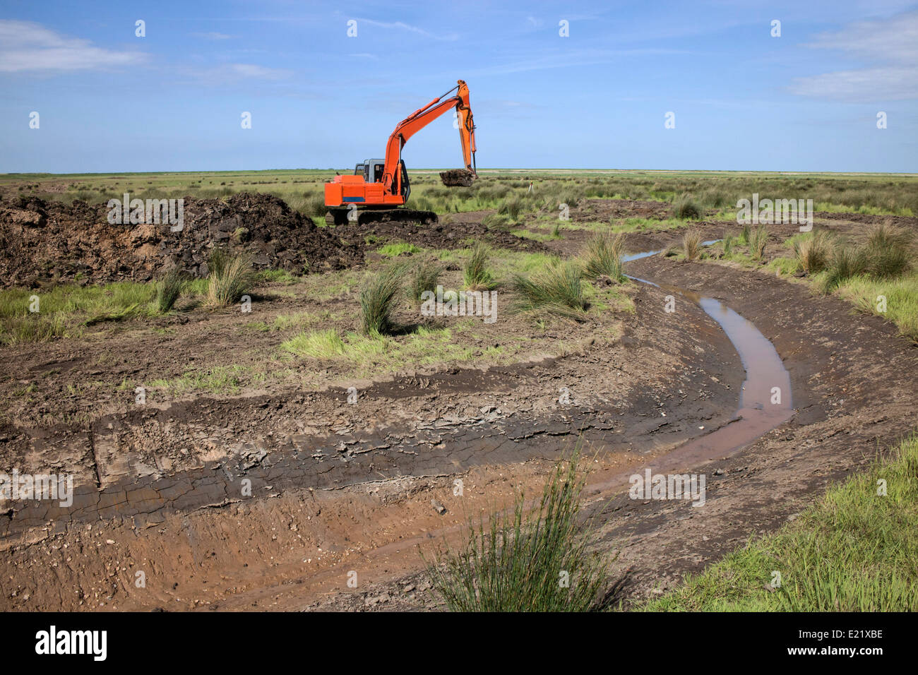 Using a digger excavator for habitat restoration work on Deepdale Marsh, Burnham Deepdale, North Norfolk. Stock Photo