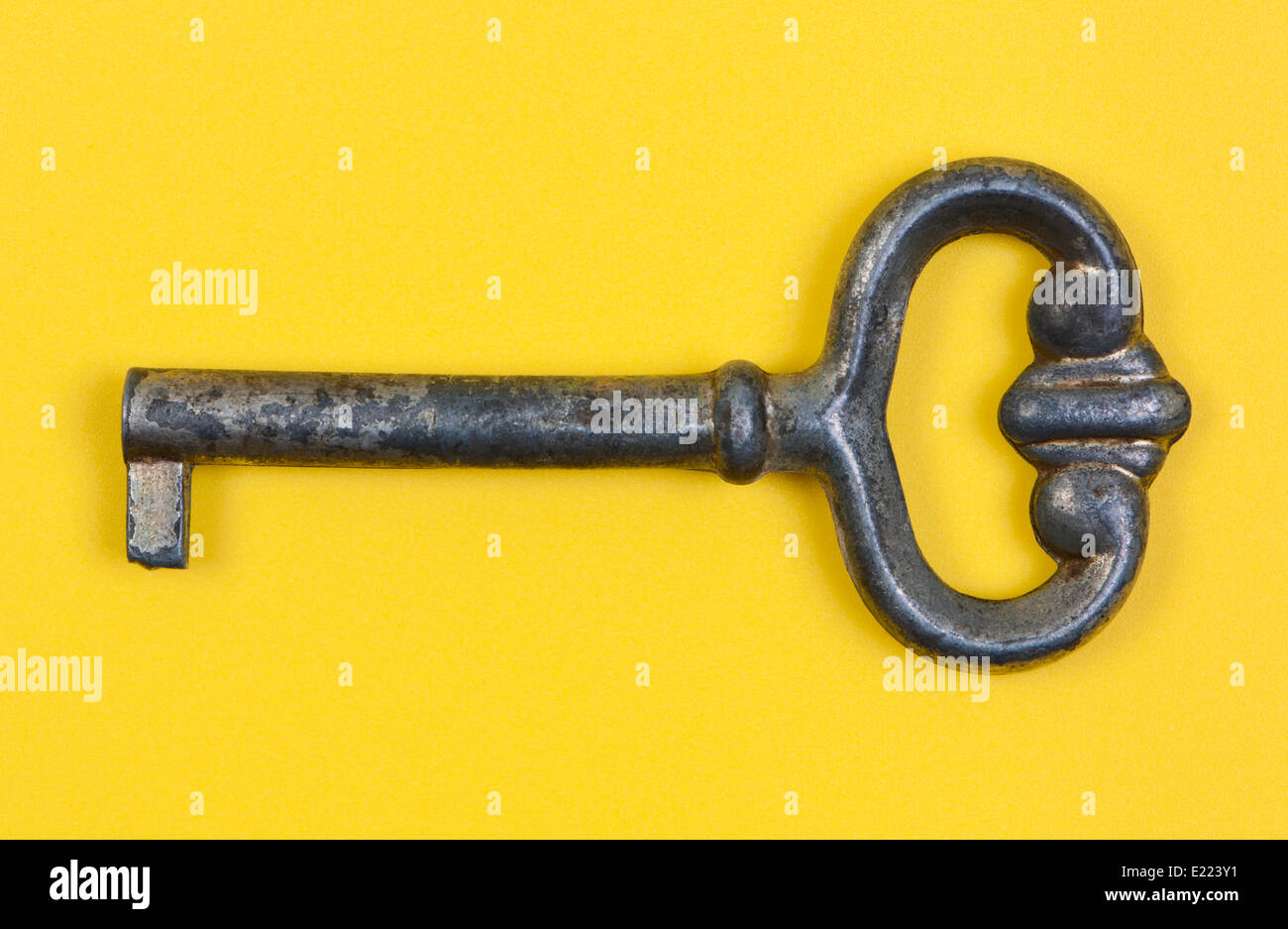 Antique key close-up on yellow background. Stock Photo