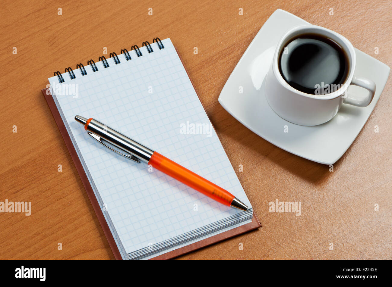 Notebook with pen and coffee on table. Stock Photo