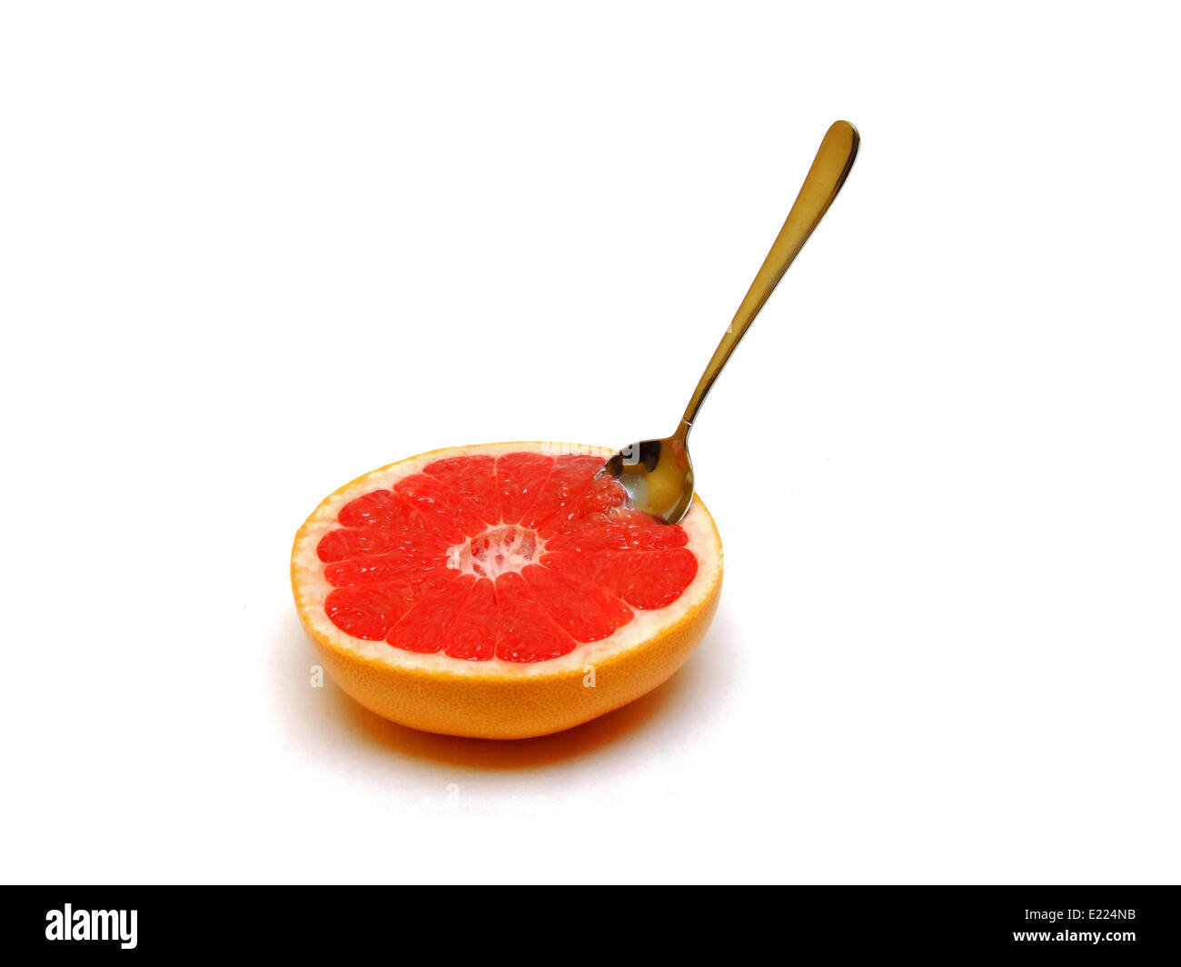 a half grapefruit with a spoon Stock Photo Alamy