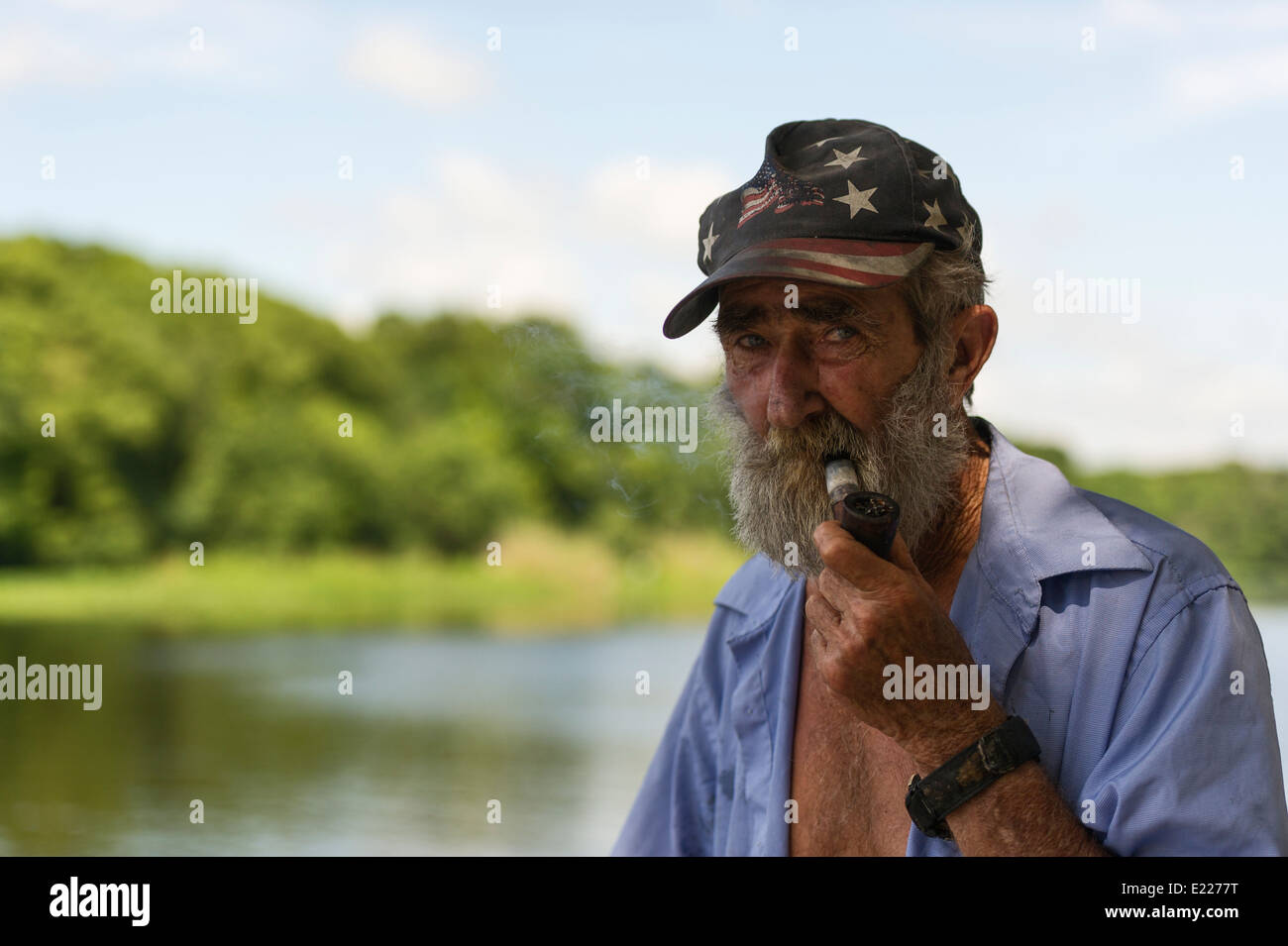 Older Man wearing a Americana patriotic hat and beard on the shores of the  St.Johns River in Central Florida, USA Stock Photo - Alamy