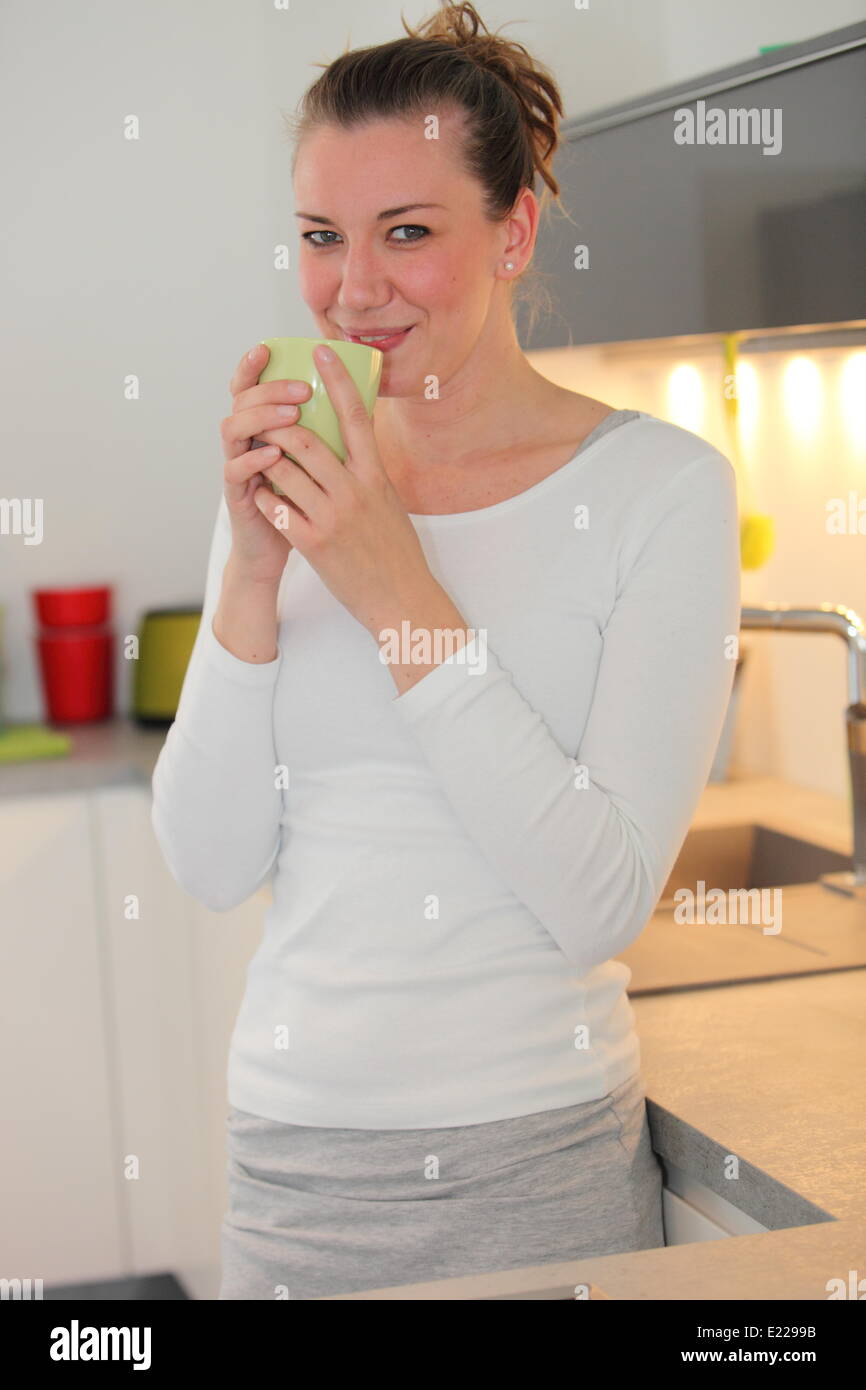 Housewife drinking coffee in her kitchen Stock Photo