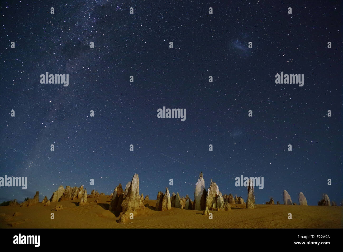 The Pinnacles Desert - this image contains part of the Milky Way, plus the Southern Cross, a meteor, and Magellanic Clouds. Stock Photo