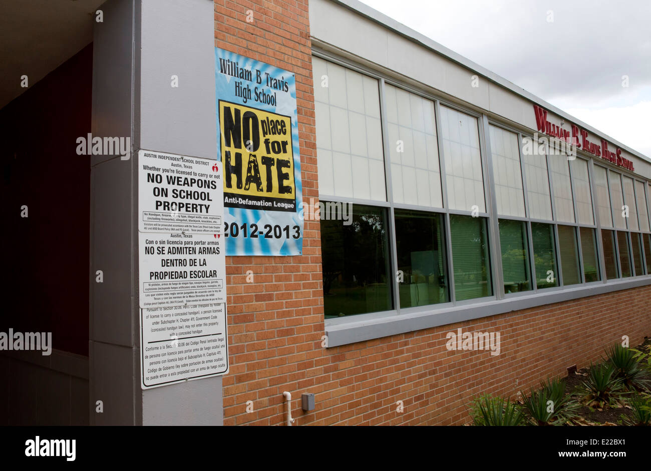 high school with bilingual signs no weapons on school property law and a poster advocating a the school as 'no place for hate' Stock Photo