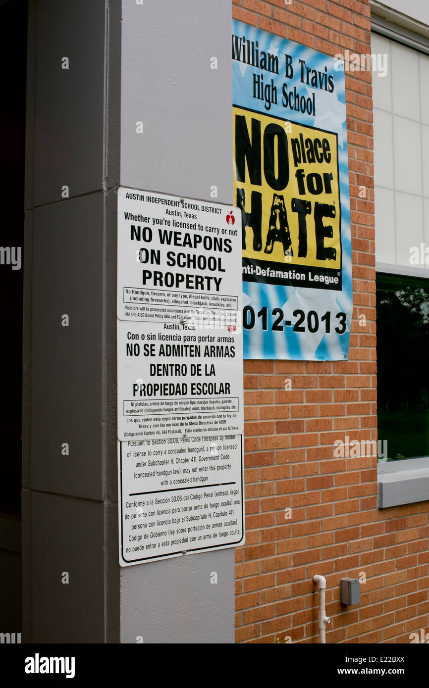 high school with bilingual signs no weapons on school property law and a poster advocating a the school as 'no place for hate' Stock Photo