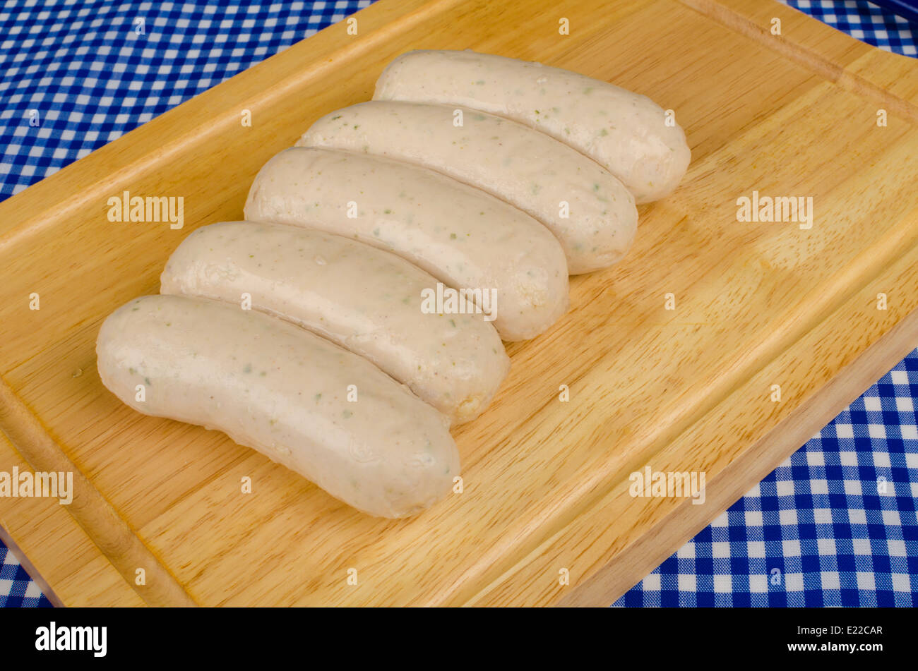 Several German Bratwurst sausages on a wooden chopping board Stock Photo